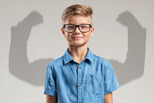 Kind vor Schatten mit muskul&ouml;sen Armen
