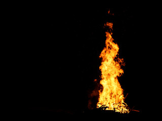 Bonfire burning trees at night. Large orange flame isolated on a black background. Fire on black. Brightly, heat, light, camping, big bonfire