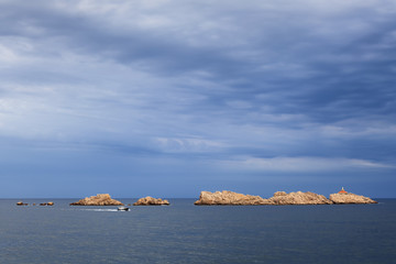Rocks in the Adriatic sea with a motorboat before storm