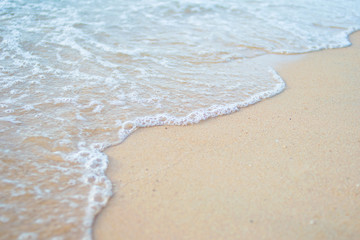 sea water waves with bubbles on sand beach