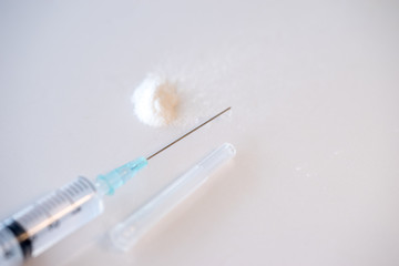 Drug syringe and cooked heroin. Studio shot