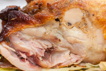 a piece of  roast chicken on wooden plate