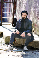 Bearded young man smokes an electronic cigarette or vape