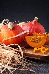 Pumpkin slices with seeds and autumn hokkaido pumpkins - obrazy, fototapety, plakaty