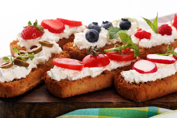 Bread Brushetta or authentic traditional spanish tapas set for lunch table. Sharing antipasti on party or summer picnic time over wooden rustic background.