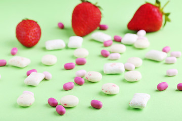 Chewing gums with strawberries on green background