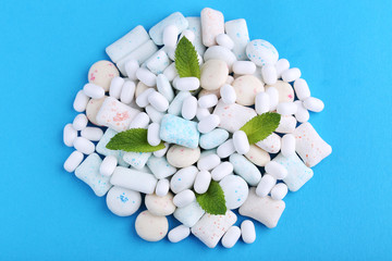 Chewing gums with mint leafs on blue background