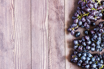 Black grape branch on dark wooden background