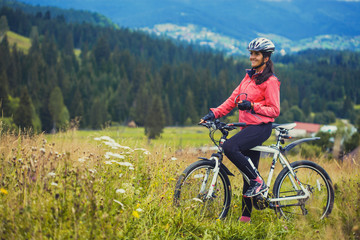 Fototapeta premium young woman riding a bicycle on the high plateau