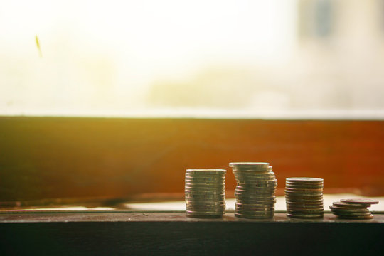 stack of coin in different position. on the edge of windows. pile of coin on the edge of windows focus on the coin stack. blur background. money finance concept.