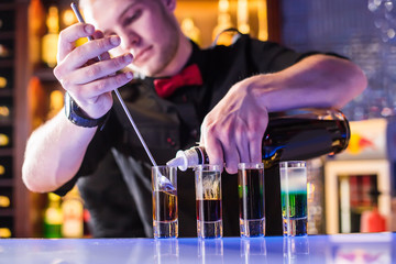 The barman pours shots on the bar