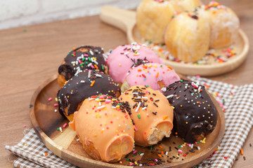 a variety of doughnut on wooden plate with sprinkles