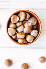 Brown chestnuts over wooden surface.