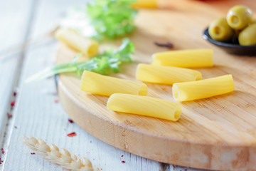 Italian tortiglioni pasta ready to cooking on kitchen board.