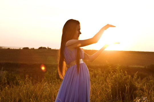The girl is holding the sun in her hands