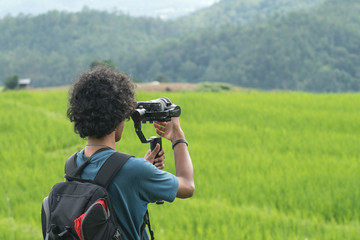 man recording documentary of nature by gimbal
