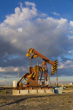 Pumpjack on the oilfield at sunset