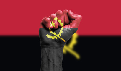 Angola flag painted on a clenched fist. Strength, Power, Protest concept - obrazy, fototapety, plakaty