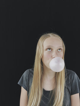 Teenage girl blowing bubble gum bubble