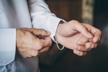 A man adjusts cuff links on his sleeve