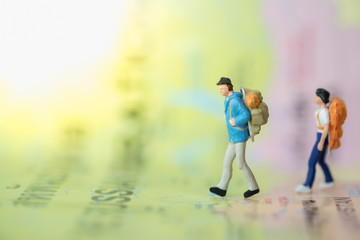 Two traveler miniature people figure with backpack walking on world map using as Travel concept.