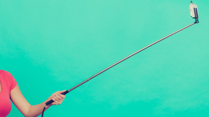Woman hand holding phone on selfie stick