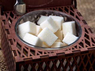 Cubes of sugar in brown wooden carved sugar