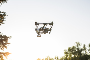 Fototapeta na wymiar White drone, quadrocopter with photo camera flying