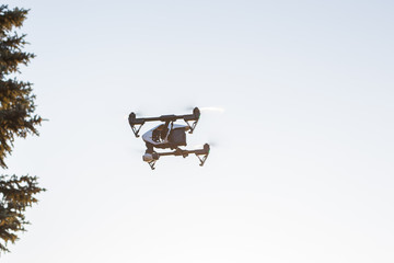 White drone, quadrocopter with photo camera flying