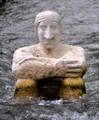 Fototapeta na wymiar old stone statue in the water photo