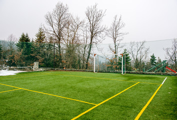 Field for soccer and other sports with trees and snow at Winter