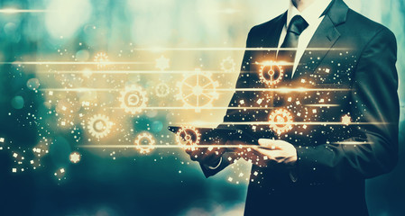 Gears with man holding a tablet computer