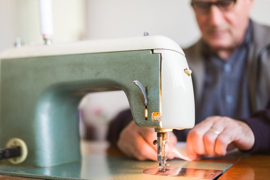 Senior male working on a sewing machine indoor