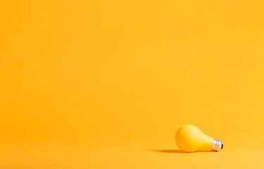 Yellow light bulb on a yellow background minimalist style