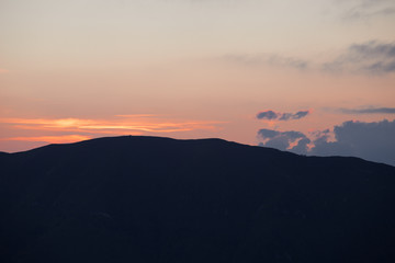 Sunset silhouette with storm in the distance, Cansiglio forest, Veneto, Italy