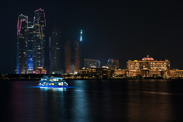 Abu Dhabi buildings skyline from the sea at night