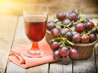 Grapes in a basket on a background of grape leaves in the sunlight