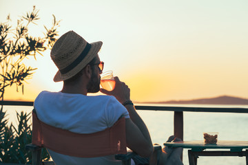 Young man enjoying sunset at a beach bar