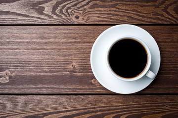 Cup of coffee on an old wooden table. Close up