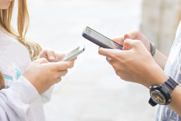 group of friends with mobile phones chatting and playing