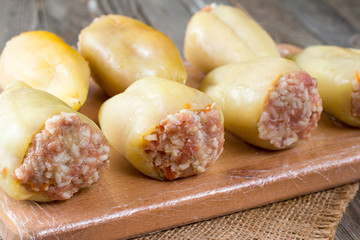 Raw stuffed peppers on a cutting board