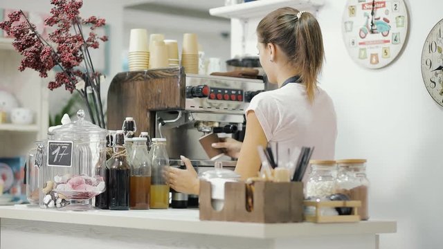 Female barista working, she make coffee for a client