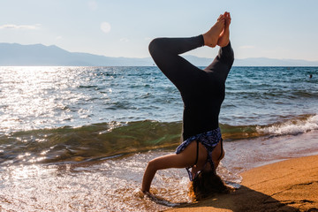 Young Woman Doing Handstand on the Sand