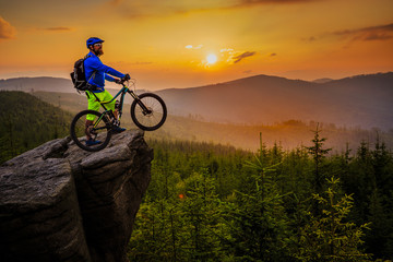Mountain biker riding on bike in autumn mountains forest landscape. Man cycling MTB flow trail track. Outdoor sport activity.