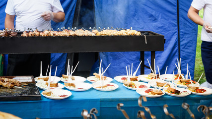 A lot of sandwiches are on a blue table in white plates.