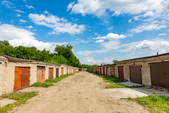 A rows of brick garages with rusty metal gates
