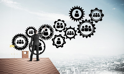 Businessman on house roof presenting teamwork and connection con