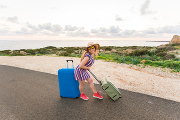 Happy traveler woman with suitcase on the beach. Concept of travel, journey, trip