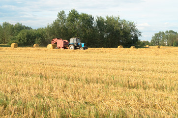 Obraz premium Special machines for harvesting form round bales of hay.