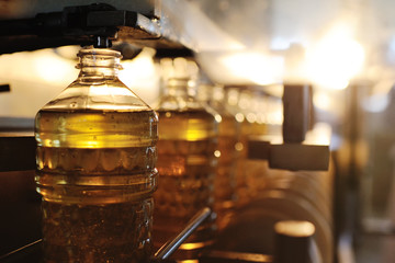 Fototapeta na wymiar Sunflower oil production plant. Bottling line of vegetable oil in bottles